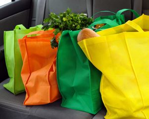 Close up of four reusable grocery bags on back seat of car